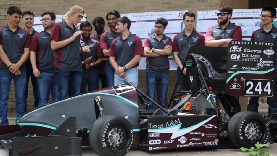 A group of guys standing around a race car.