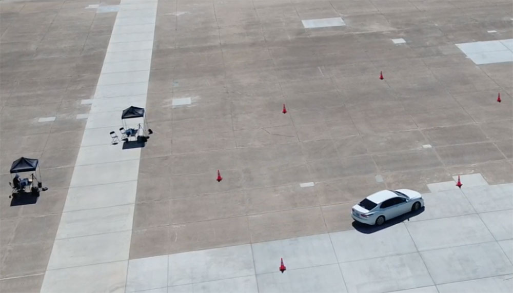 Car in parking lot with cones surrounding