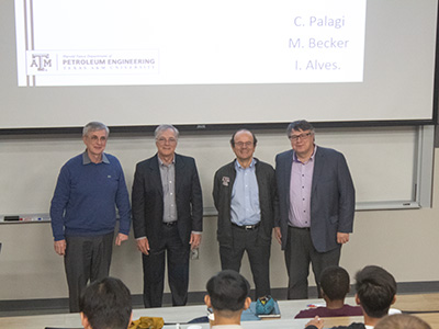 Four men standing together at the front of classroom