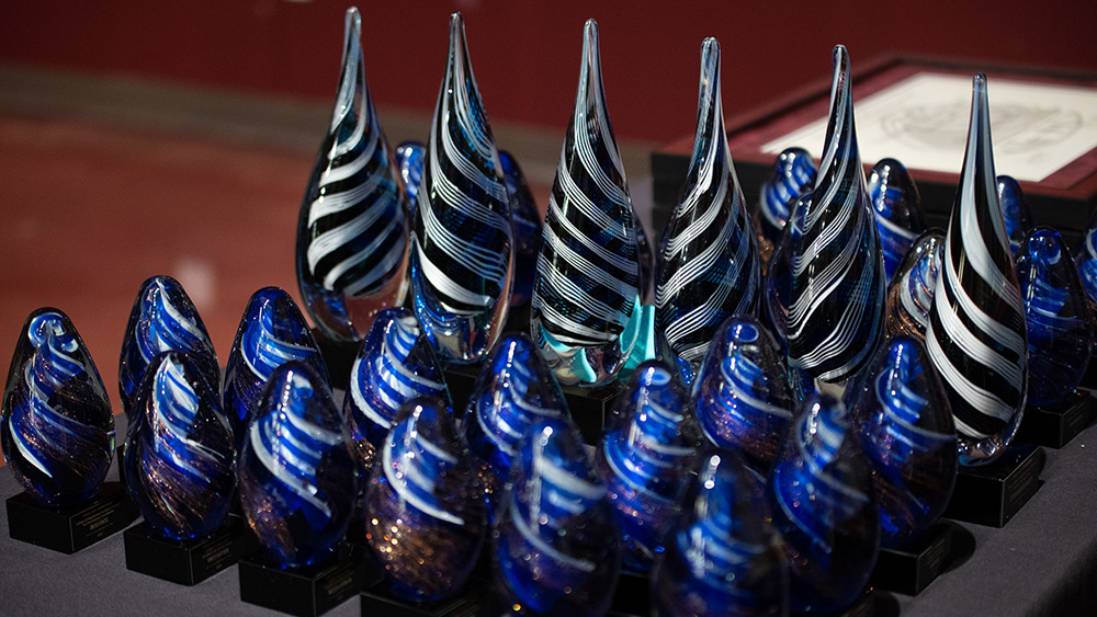 Faculty Excellence Awards trophies sitting on a table. 