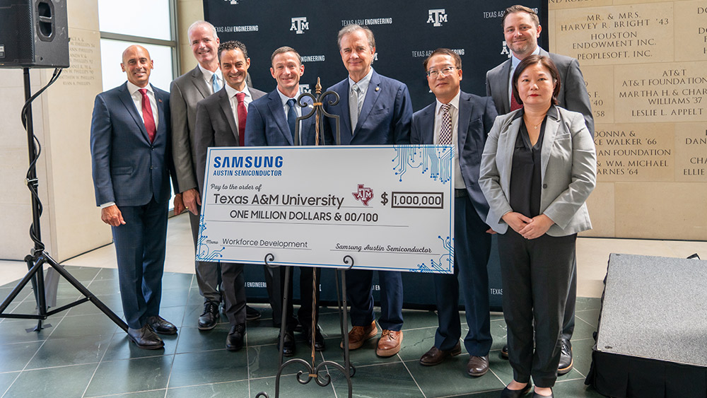 Group of people standing behind large check at Samsung signing event