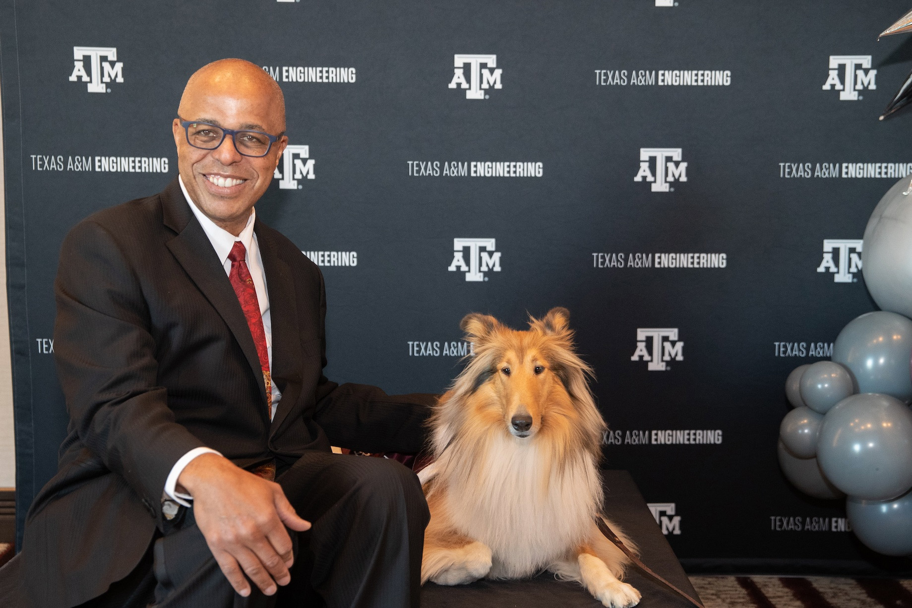 Man and dog pose for photo.