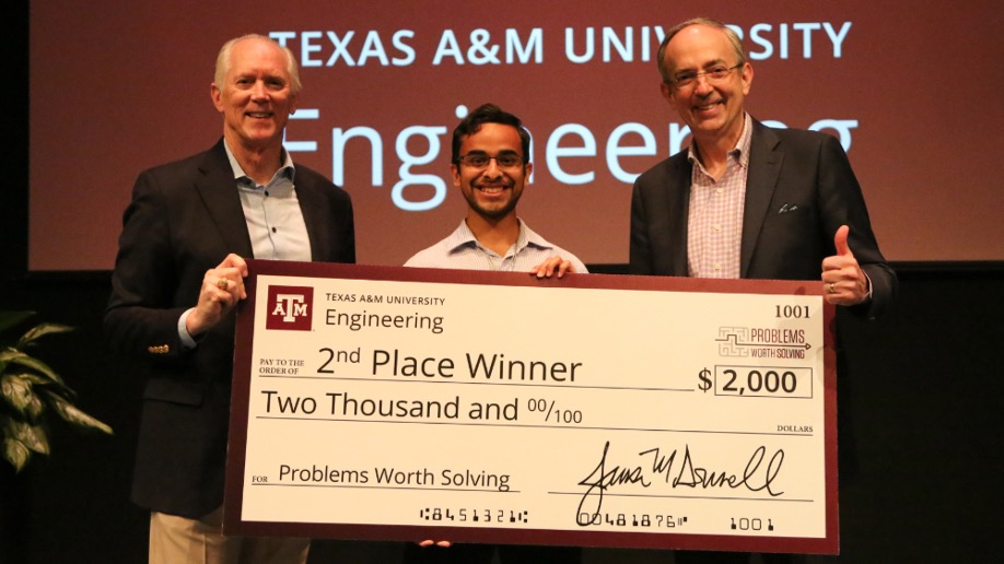 Three men hold a large check for $2,000. 