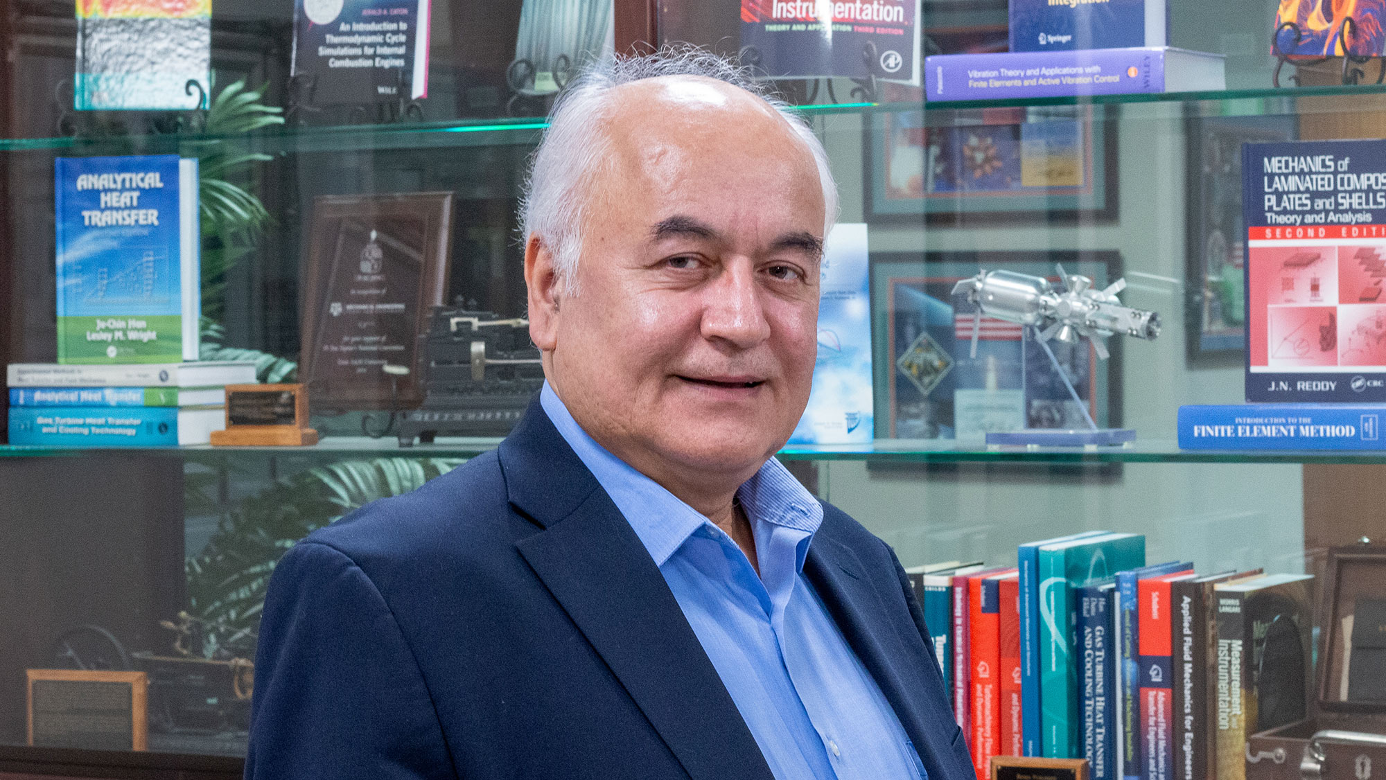 A man standing in front of a bookshelf.