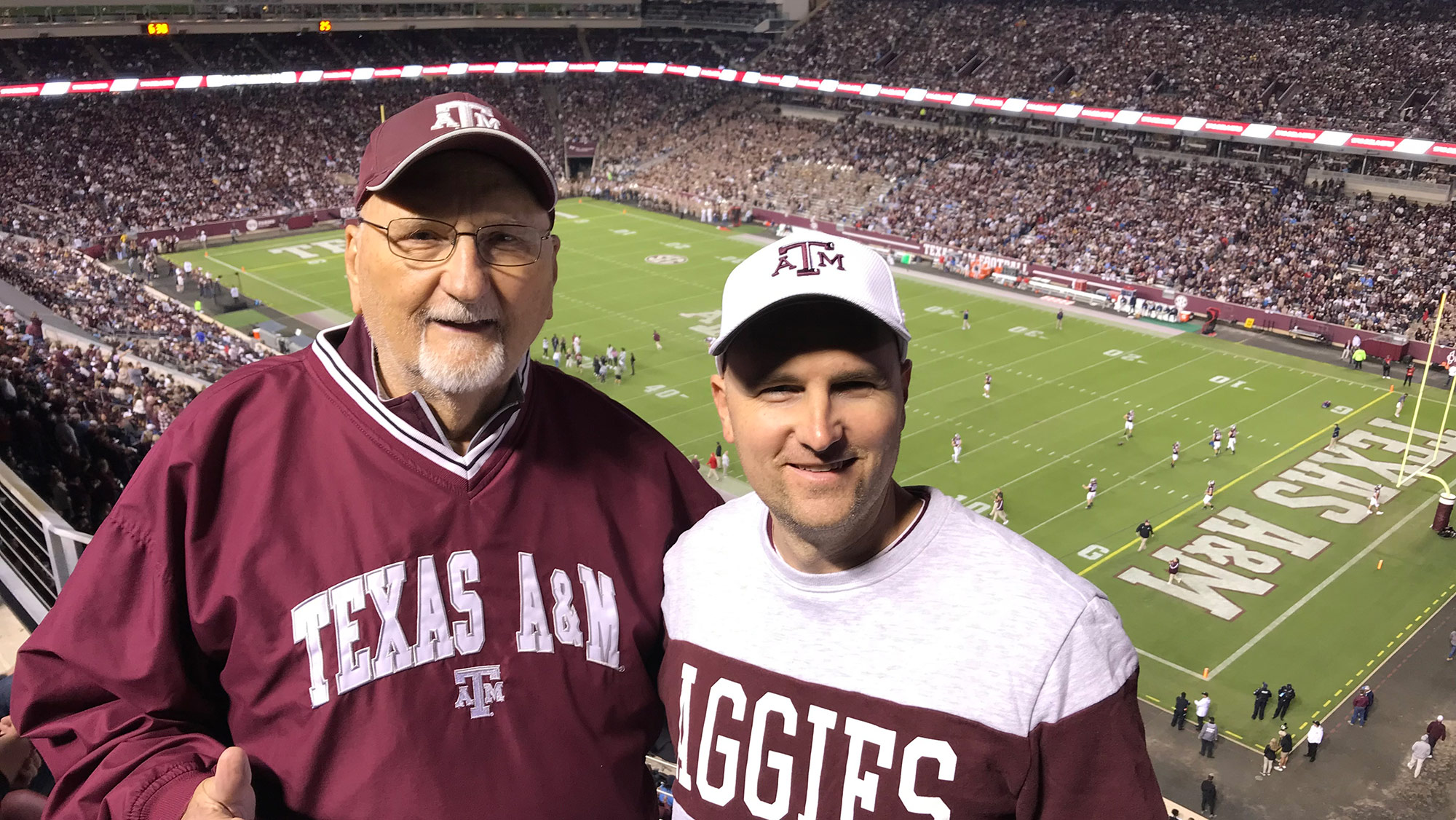 Two men standing in a stadium.