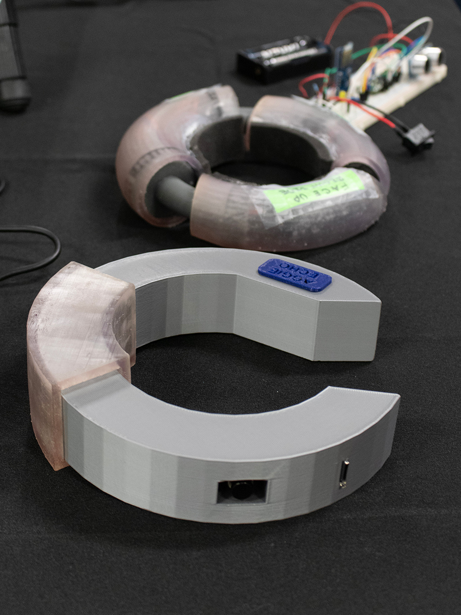 A gray, plastic collar next to another uncovered collar attached to a circuit board. 