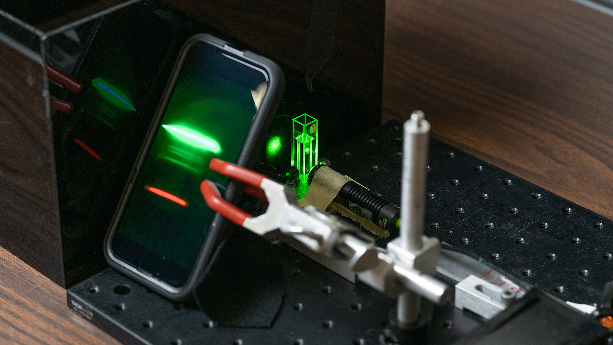 Smartphone secured in a testing rig with a green laser for inducing Raman scattering from the sample.