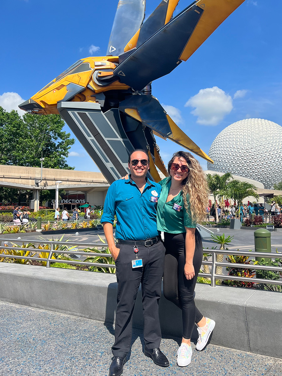 Man and woman posing in front of statue.