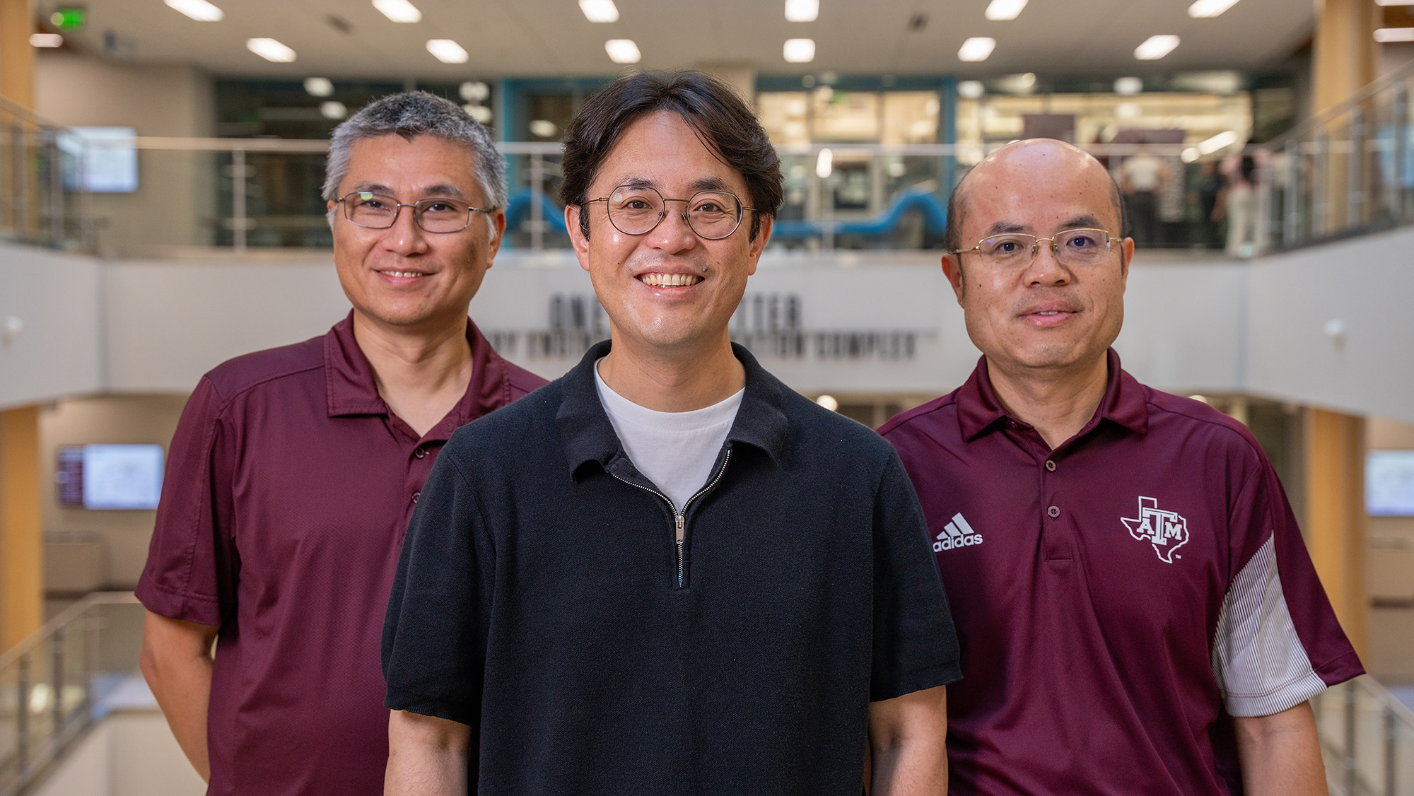 Three faculty members standing. 