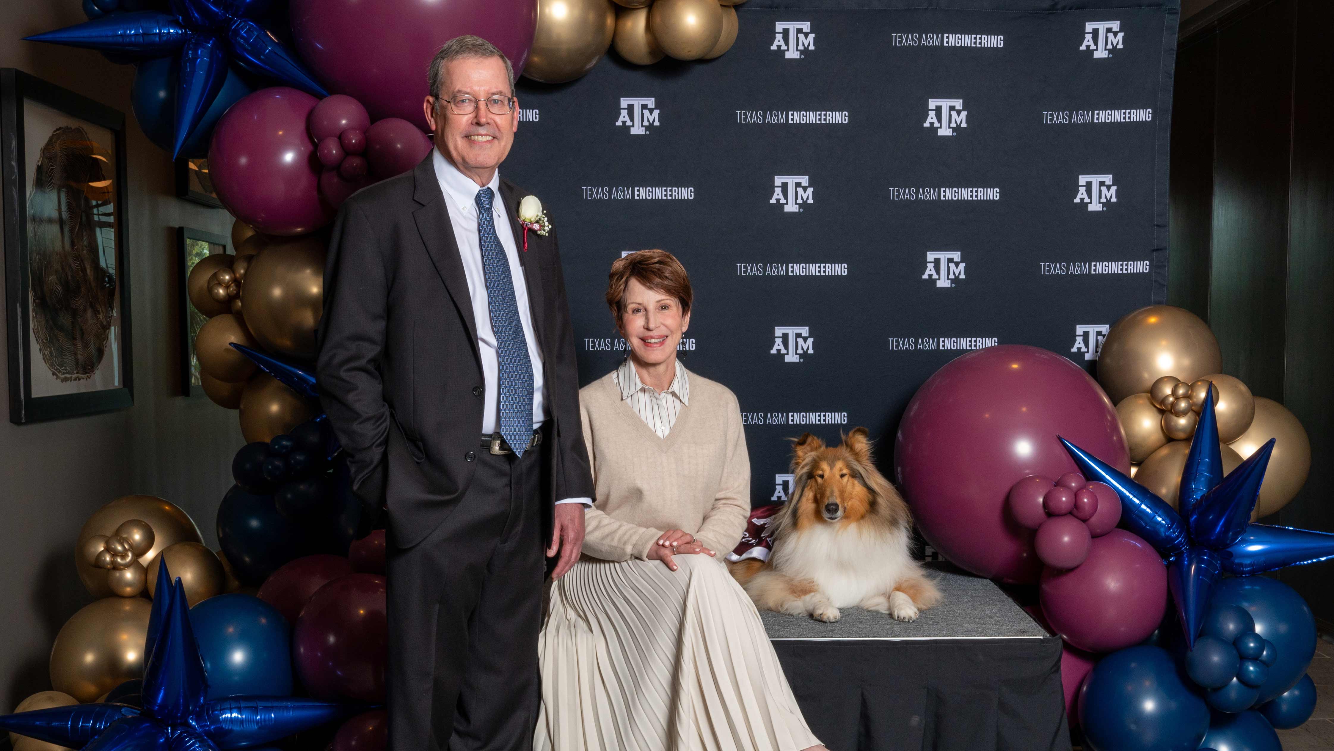 Man and woman sitting with a dog.