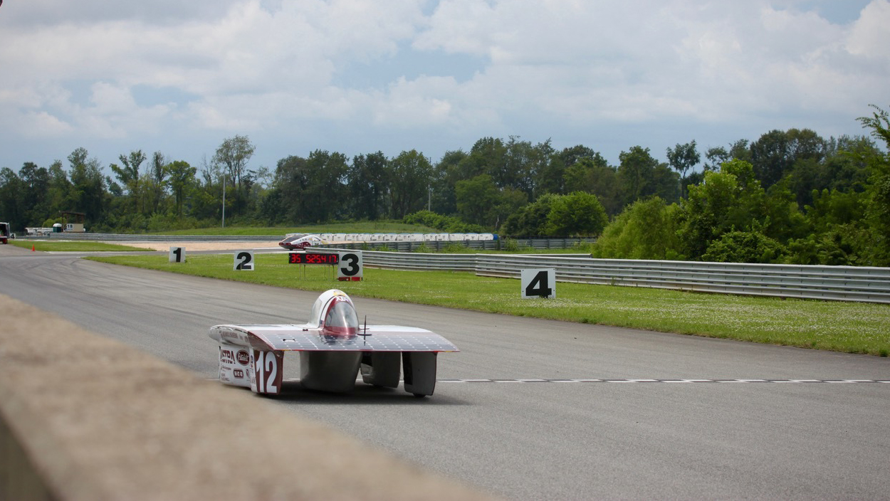 Solar car racing on a track.