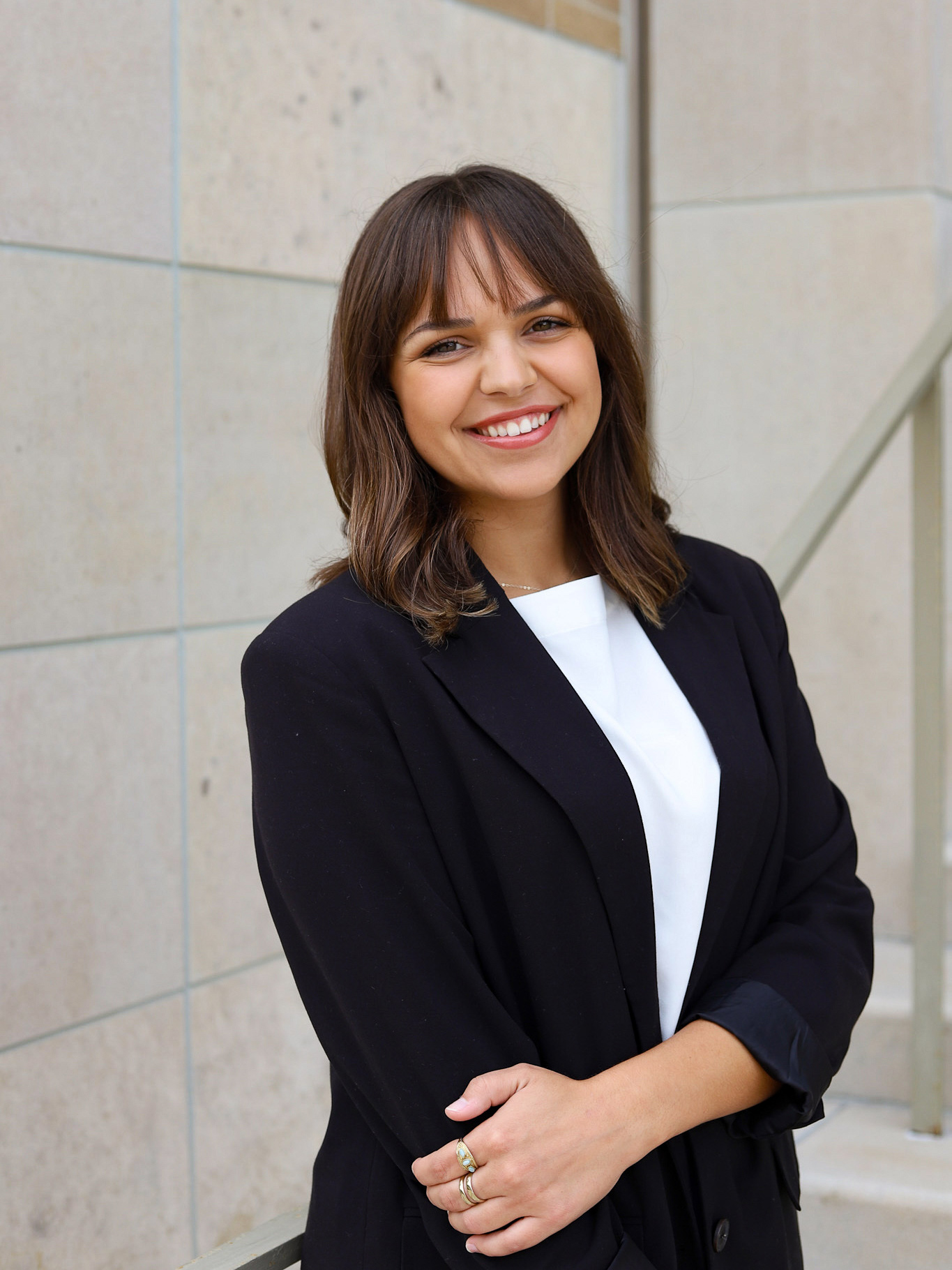 An individual in business attire standing in front of a wall. 