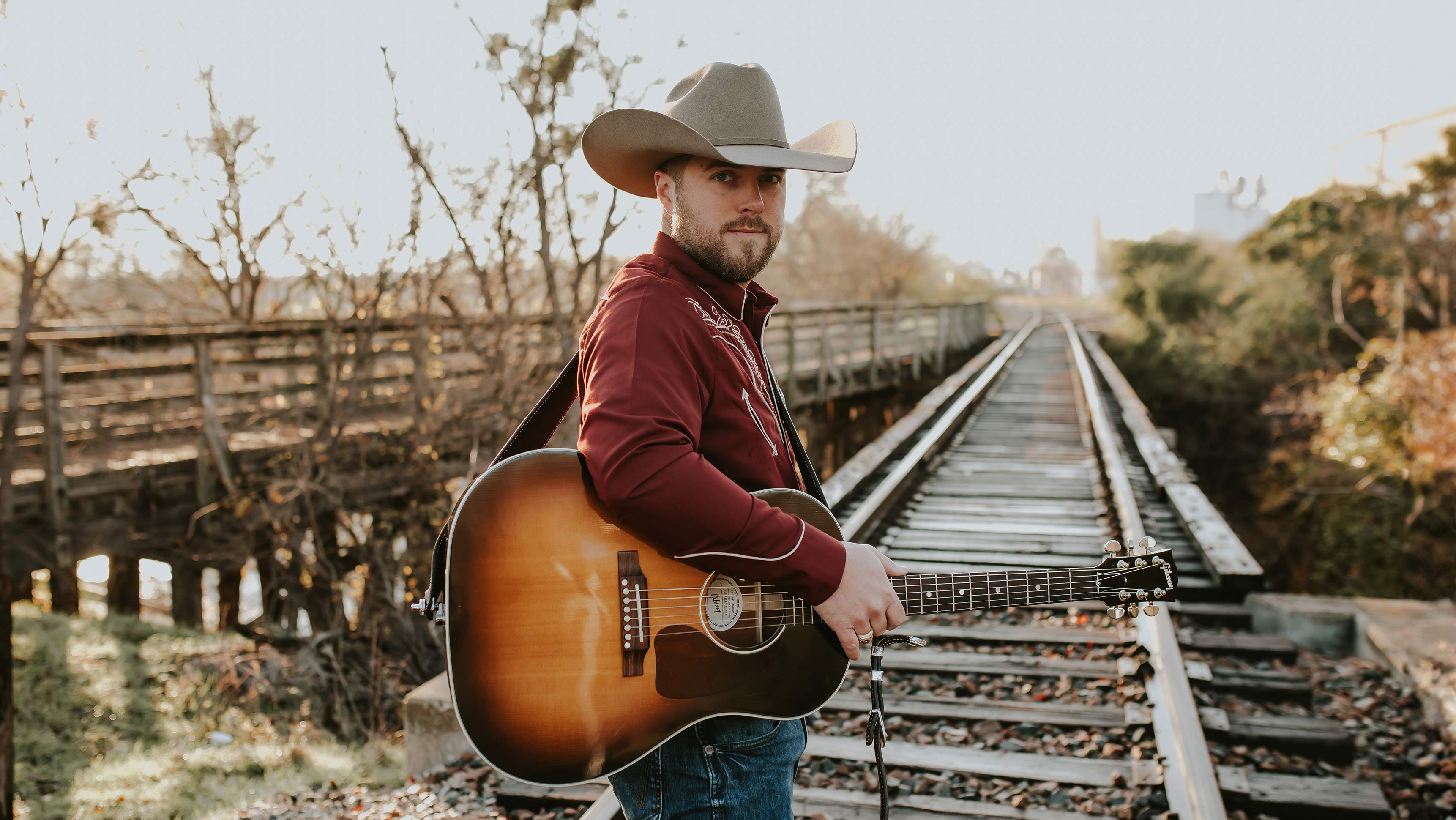 Man poses with guitar.