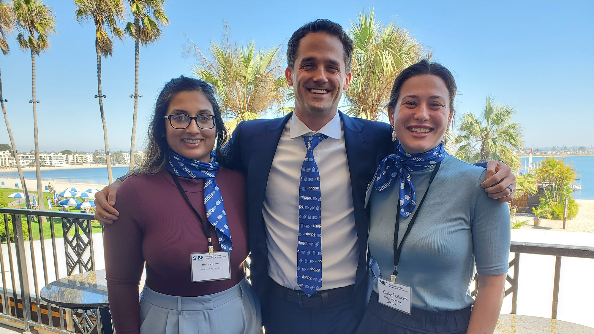 Three people in business casual wearing Shape Memory Medical apparel. 