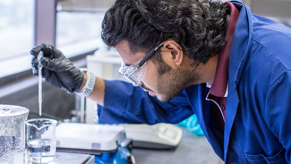 male petroleum engineering student at Texas A&amp;M University studying chemical reaction in lab