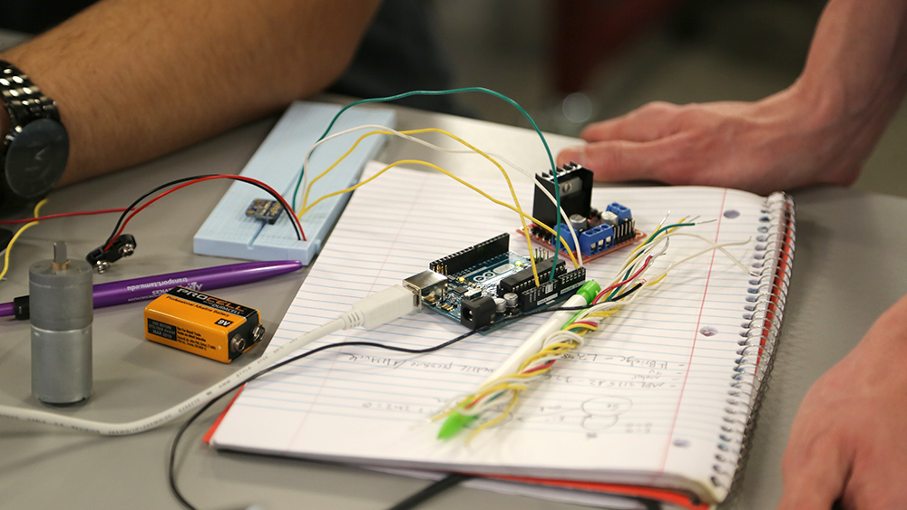 Students put together technology on a table