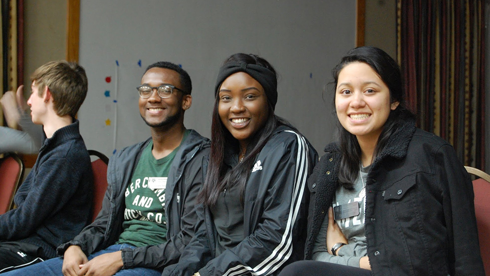 Three students smile for a photo