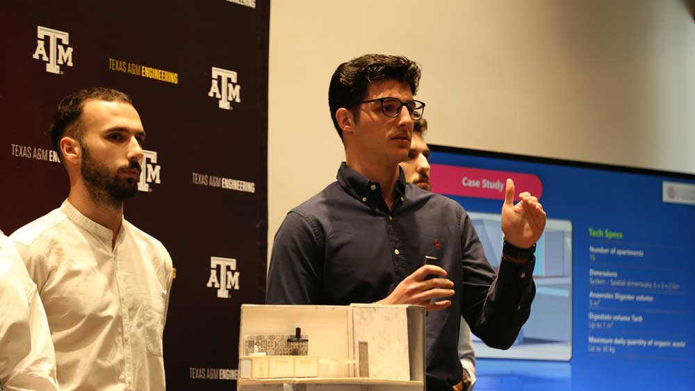 Man giving a presentation with people around him